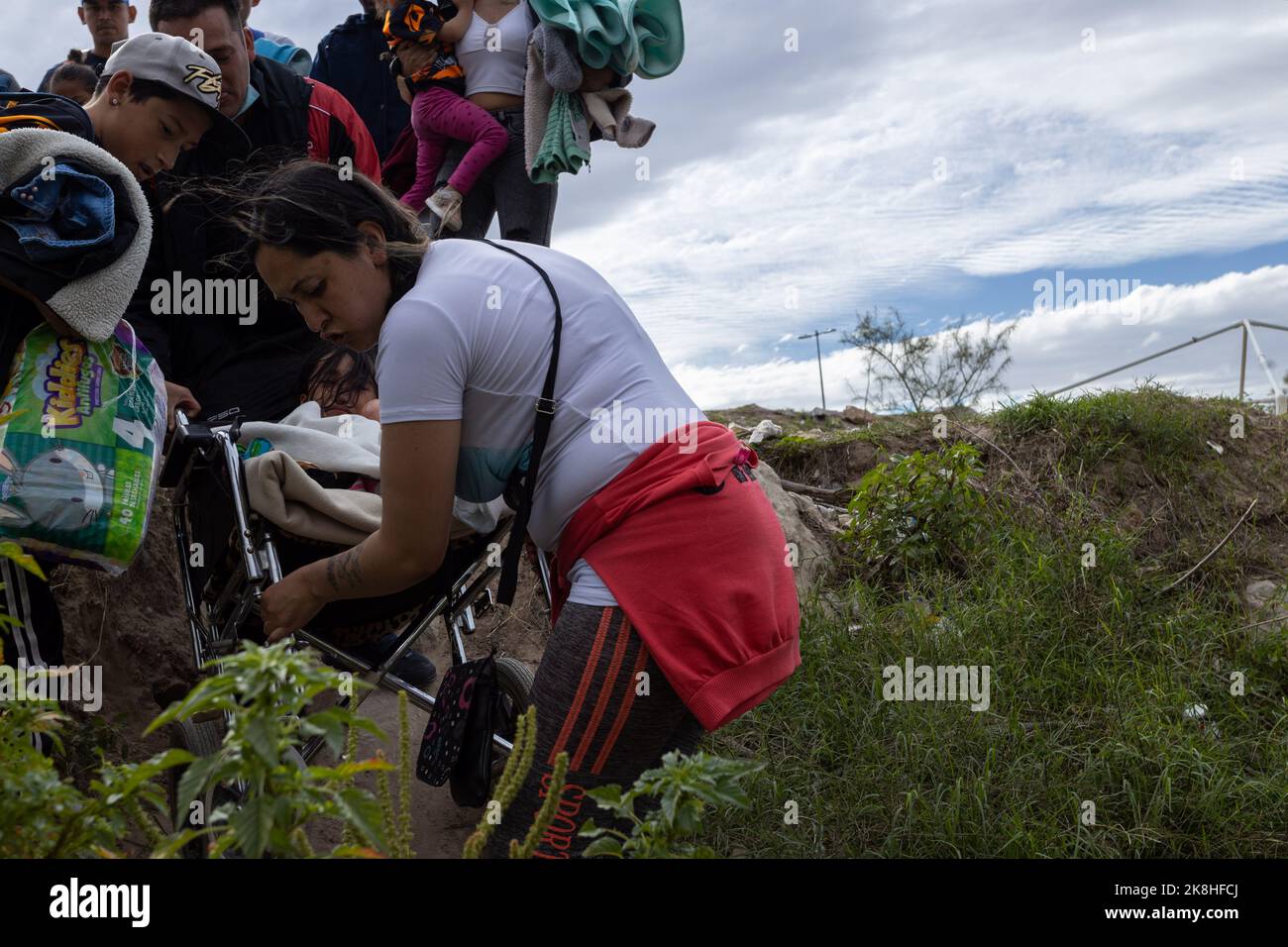 Juarez, Chihuahua, Mexico. 23rd Oct, 2022. Migrants from Venezuela crossed the Rio Grande to surrender to the border patrol with the intention of requesting humanitarian asylum, a Venezuelan couple crossed carrying their disabled daughter in their wheelchair (Credit Image: © David Peinado/ZUMA Press Wire) Credit: ZUMA Press, Inc./Alamy Live News Stock Photo