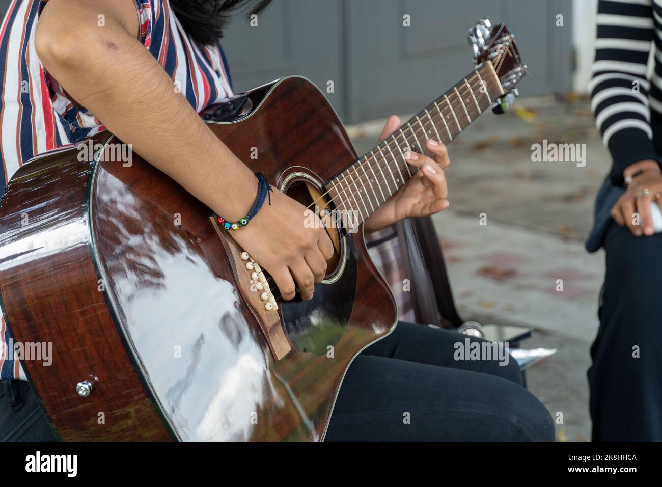 latina woman playing guitar in the street, young brunette woman, latin america Stock Photo