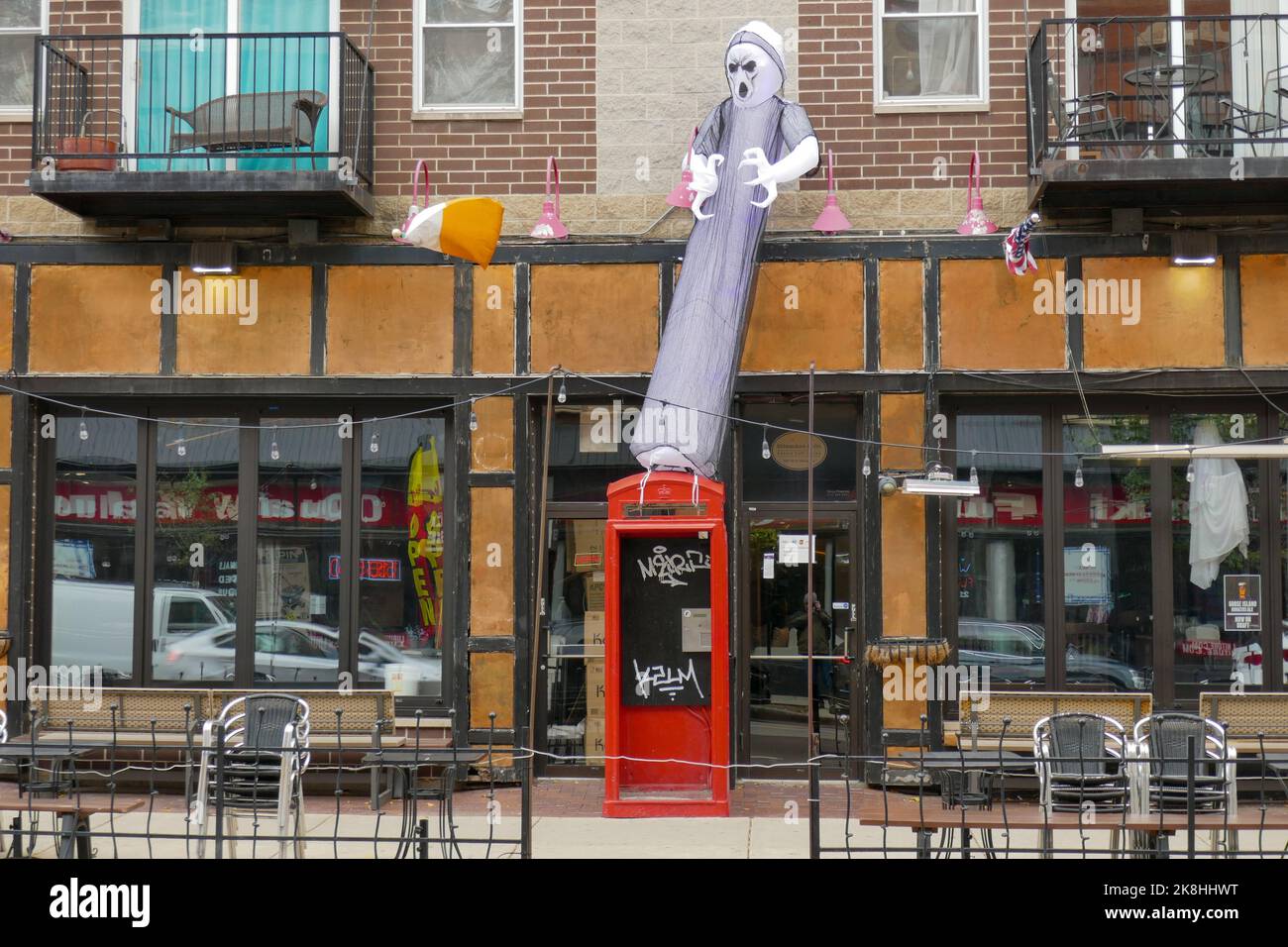 A giant ghoul decoration fastened to a British style phone booth. Wicker Park neighborhood, Chicago, Illinois. Stock Photo