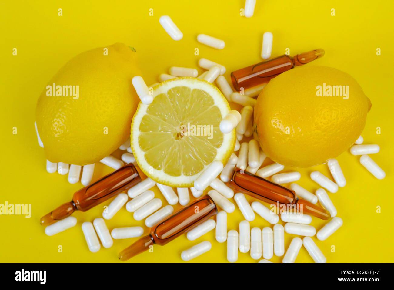 Vitamin C tablets on a yellow background. pills and citrus fruits