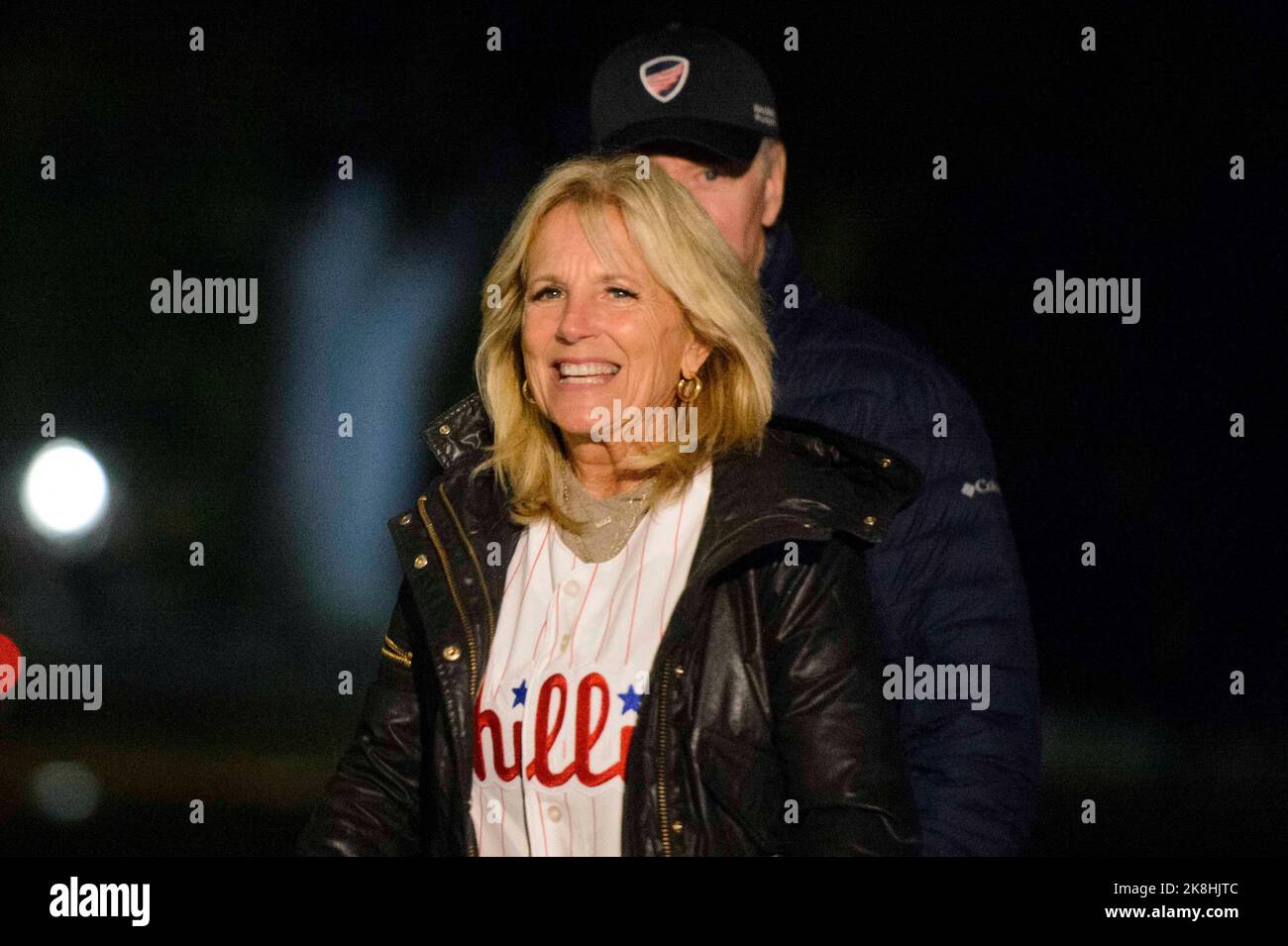 First Lady Jill Biden, wearing a Philadelphia Phillies jersey, smiles at  the press after departing Marine One at the White House in Washington, DC  on Sunday, October 23, 2022. The Phillies advanced
