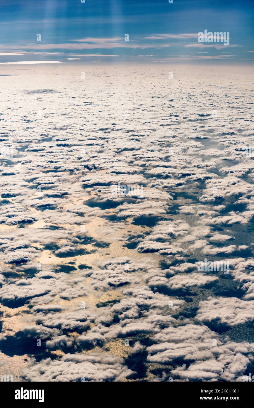 A layer of scattered cumulus clouds from above, with the warm late afternoon sunlight reflected in the South China Sea Stock Photo