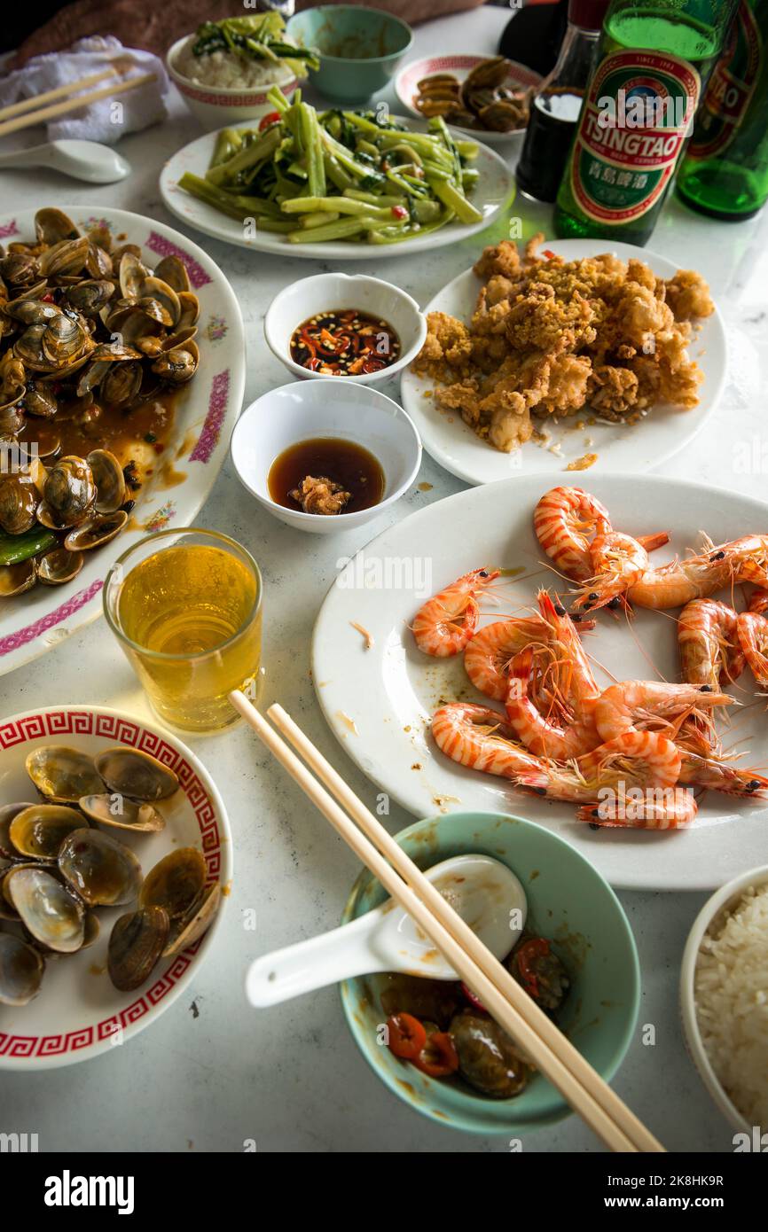 Simple meal at a cooked food market (steamed prawns, salt & pepper fried squid, clams in black bean sauce}, Mui Wo Lantau Island, Hong Kong Stock Photo