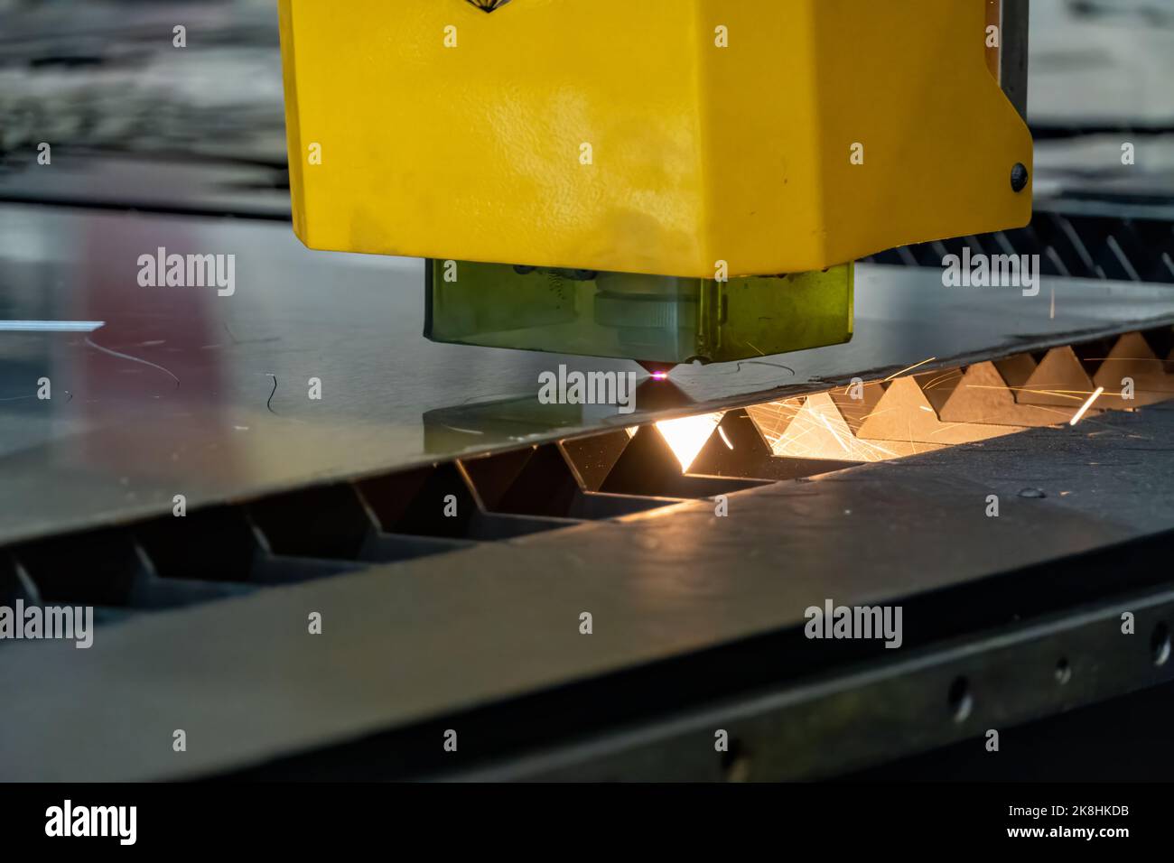 laser cutting machine, cutting wood sheets, while a man takes care of