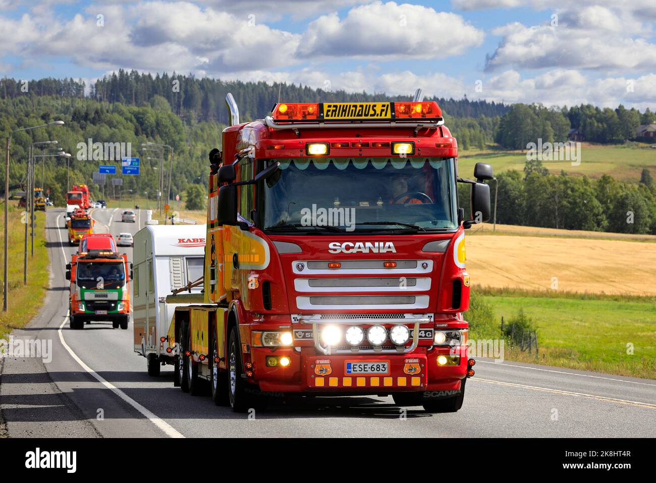 Customised Scania 4-series heavy duty tow truck Erihinaus pulls caravan in convoy to Power Truck Show 2022. Pirkanmaa, Finland. August 11, 2022. Stock Photo