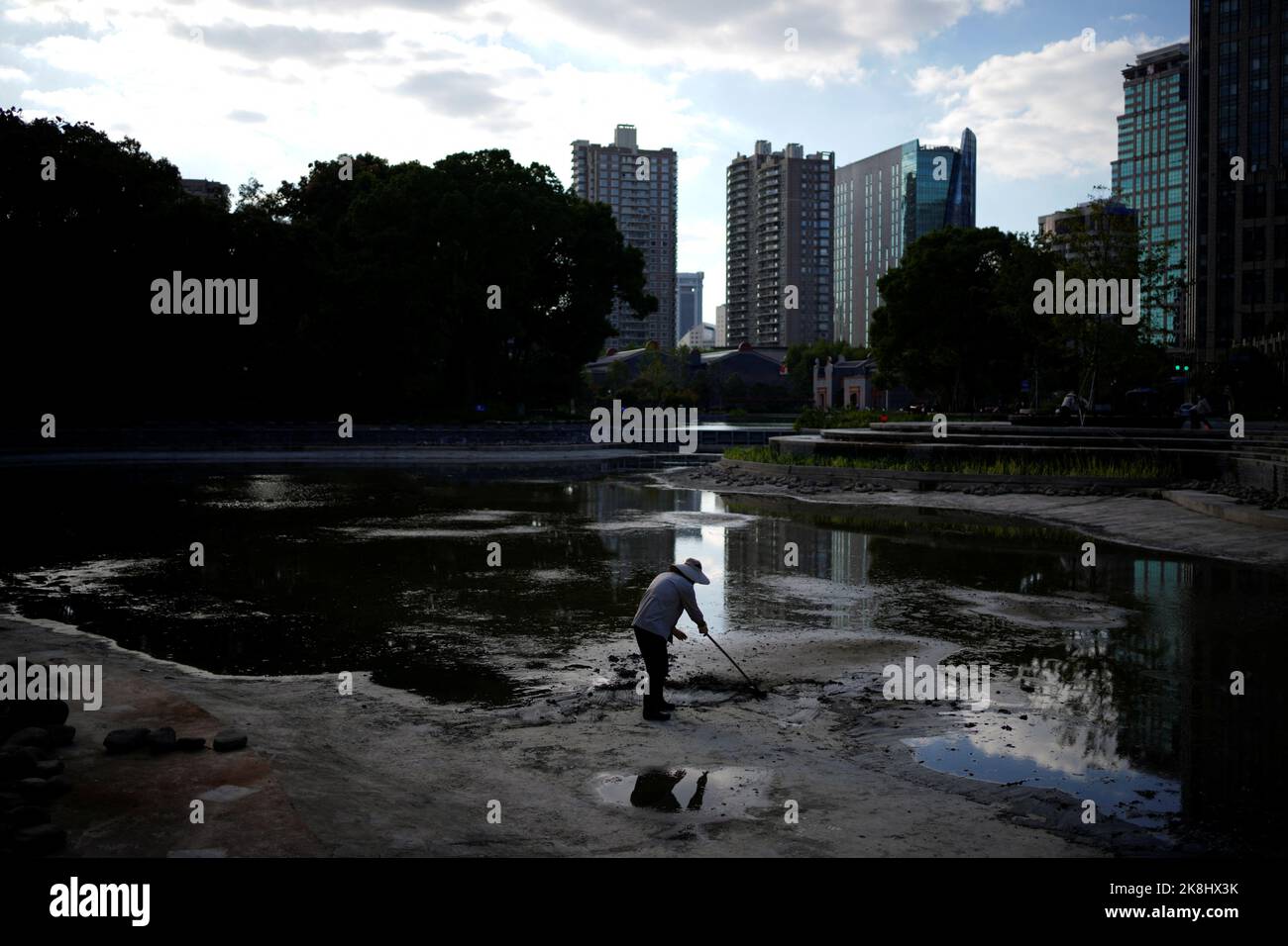 A worker works at the lake bed, following the coronavirus disease (COVID-19) outbreak, in Shanghai, China, October 12, 2022. REUTERS/Aly Song Stock Photo