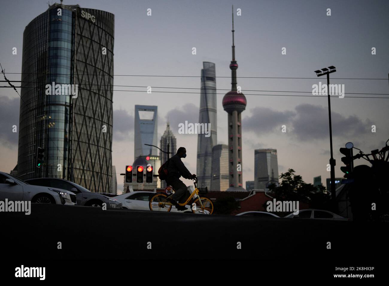 A man wearing a face mask rides a bike on a street following the coronavirus disease (COVID-19) outbreak, in Shanghai, China, October 13, 2022. REUTERS/Aly Song Stock Photo