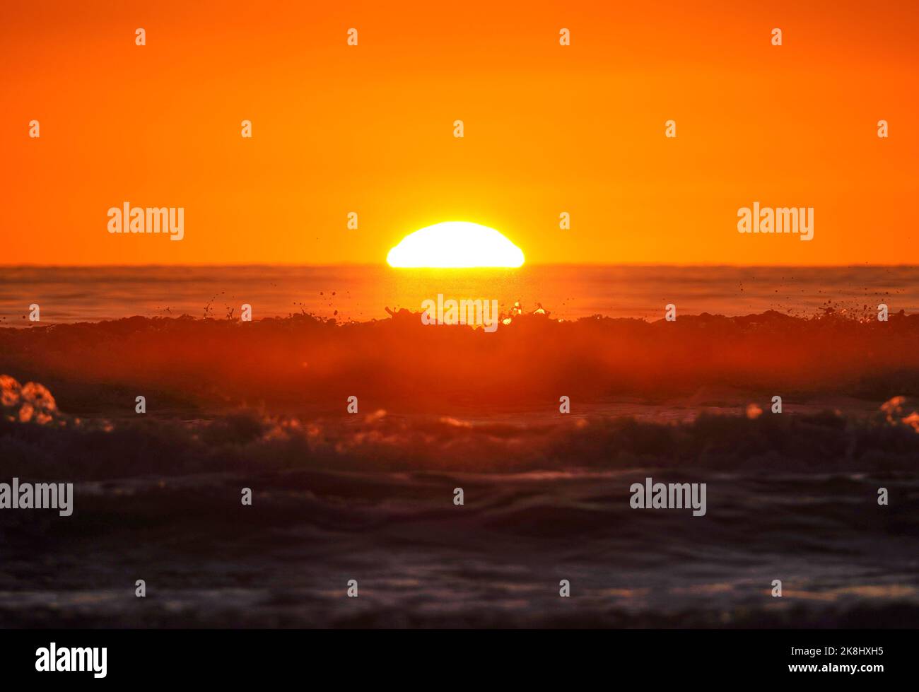 sun-goes-down-behind-the-waves-stock-photo-alamy