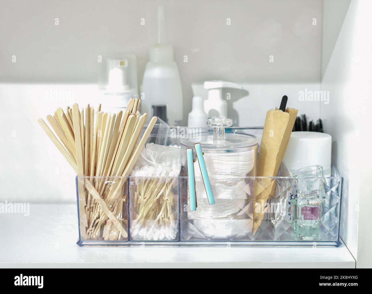 bathroom shelf with beauty care accessories, cotton swabs, disks, wooden sticks, cream bottles and lotion. face skin care and hygiene Stock Photo