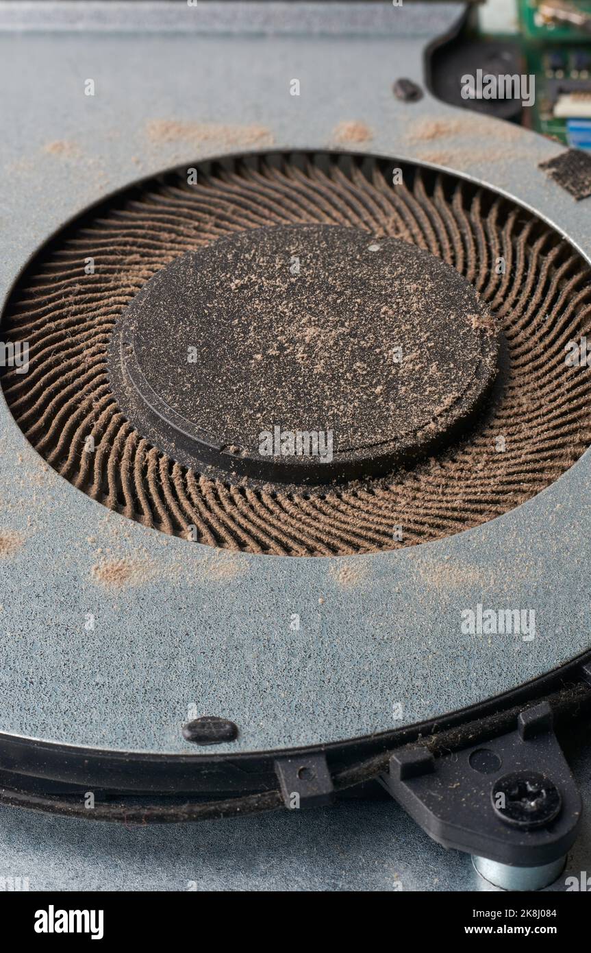 closeup of dusty laptop cooling fan, cleaning dust particles in