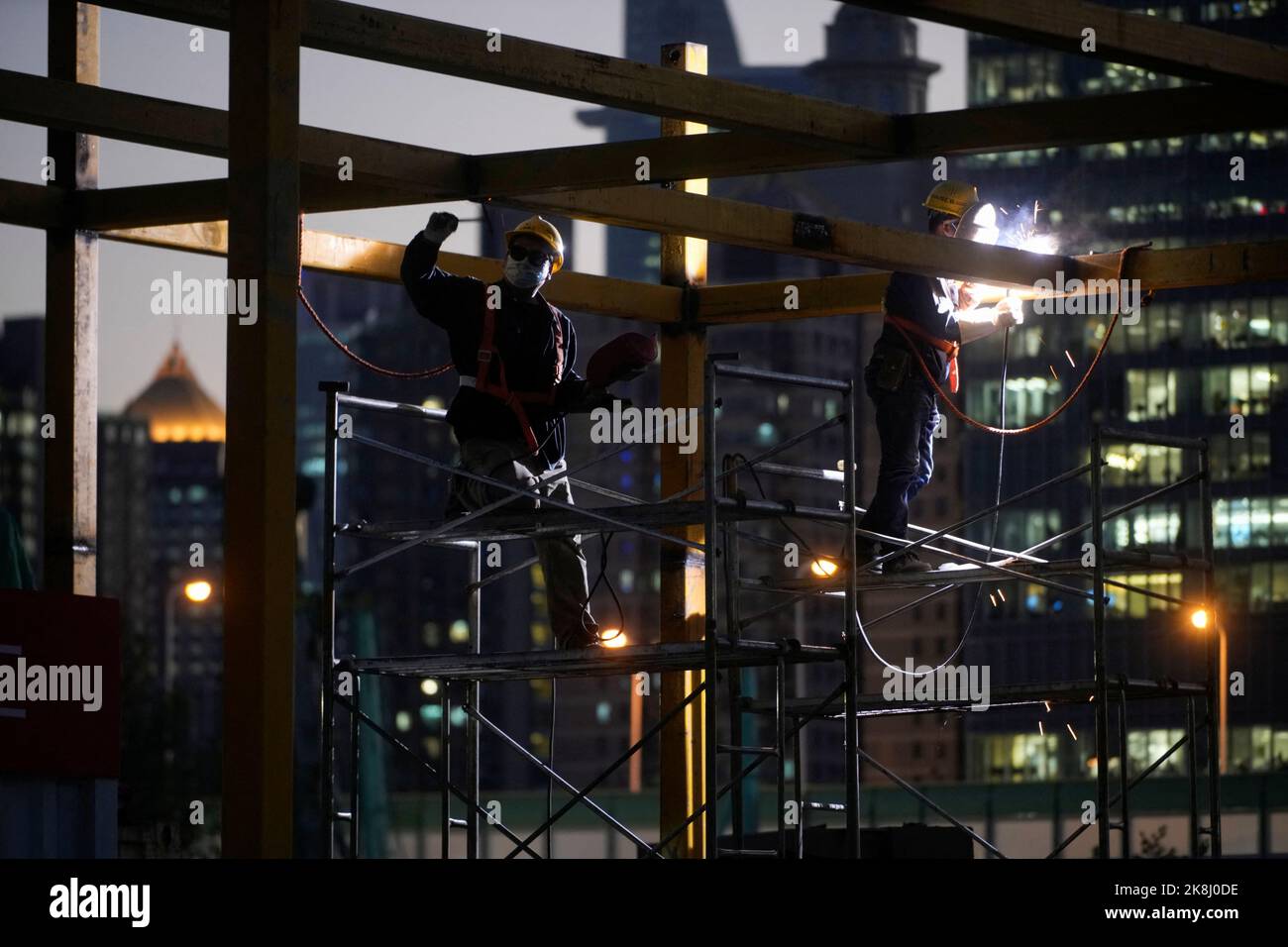 Workers work at a construction site, following the coronavirus disease (COVID-19) outbreak, in Shanghai, China, October 13, 2022. REUTERS/Aly Song Stock Photo