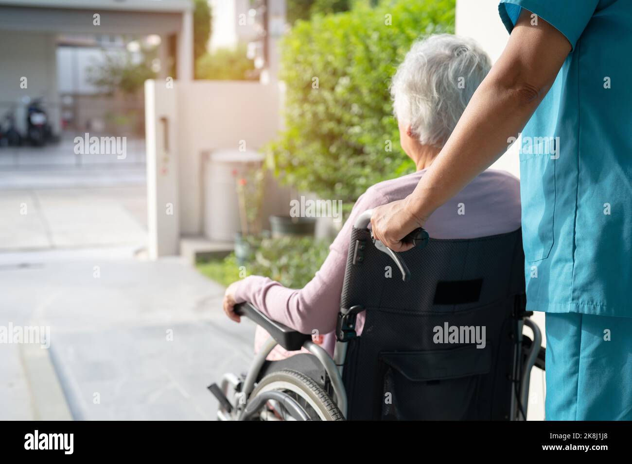 Caregiver help and care Asian senior or elderly old lady woman patient ...