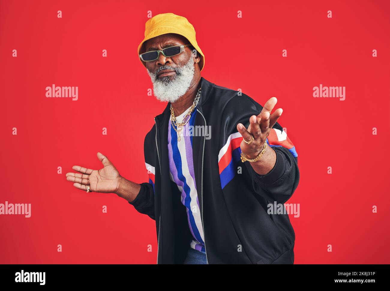 Dress however you want. Studio shot of a senior man wearing retro attire while posing against a red background. Stock Photo