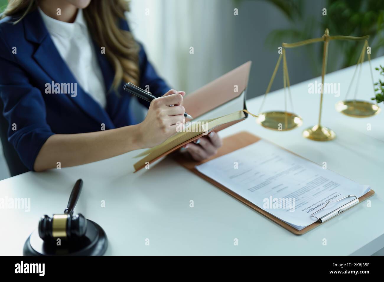 Portrait of a young Asian lawyer studying a lawsuit for a client using notebooks and paperwork on a desk Stock Photo