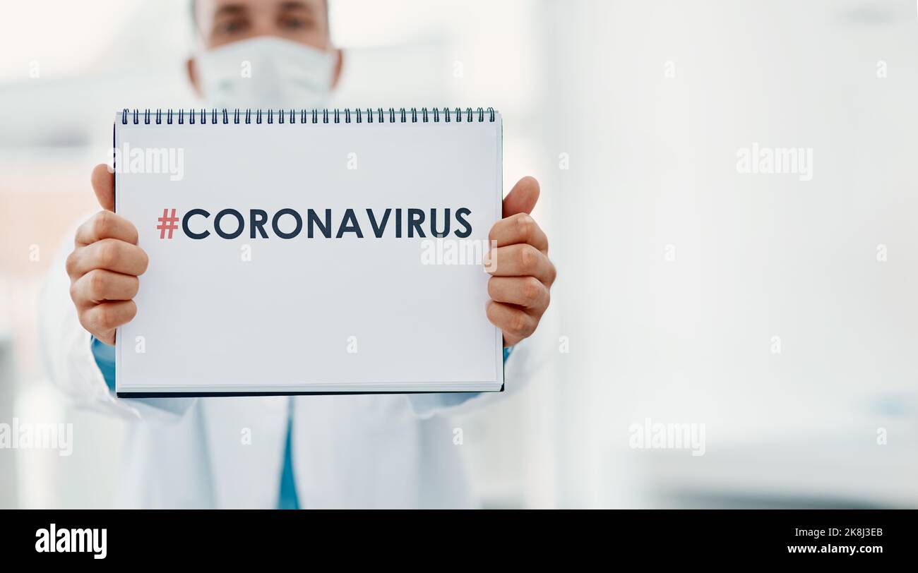 Everyones talking about it. a scientist holding a sign with CORONAVIRUS