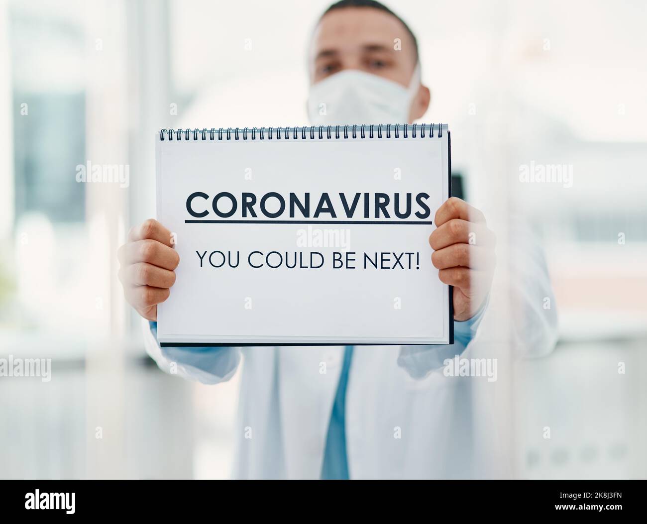 No one is invincible. a scientist holding a sign with CORONAVIRUS-YOU ...