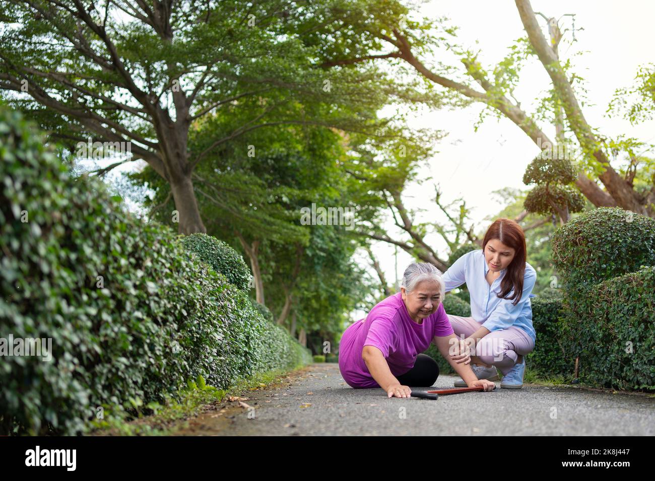 Asian senior woman fell down on lying floor because faint and limb weakness and Crying in pain form accident and her daughter came to help support. Co Stock Photo