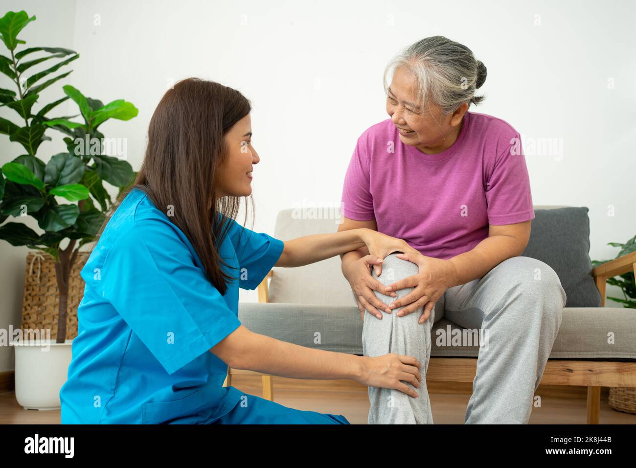 physiotherapist doctor or caregiver helping senior older woman stretching his hamstring and doing thigh or leg rehabilitation in exercise room, Osteoa Stock Photo