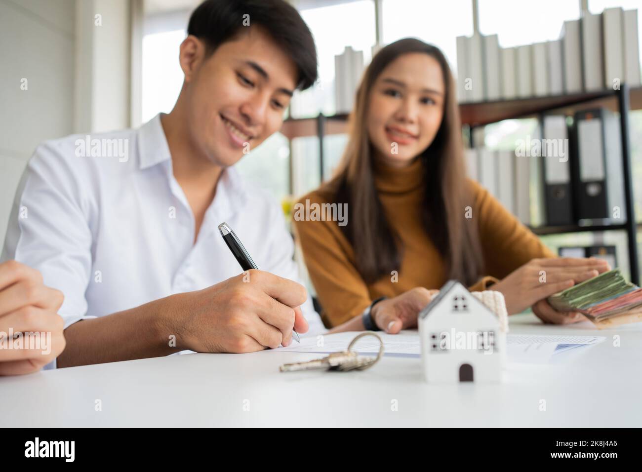 Client signs home loan document to buy homes with real estate property ...