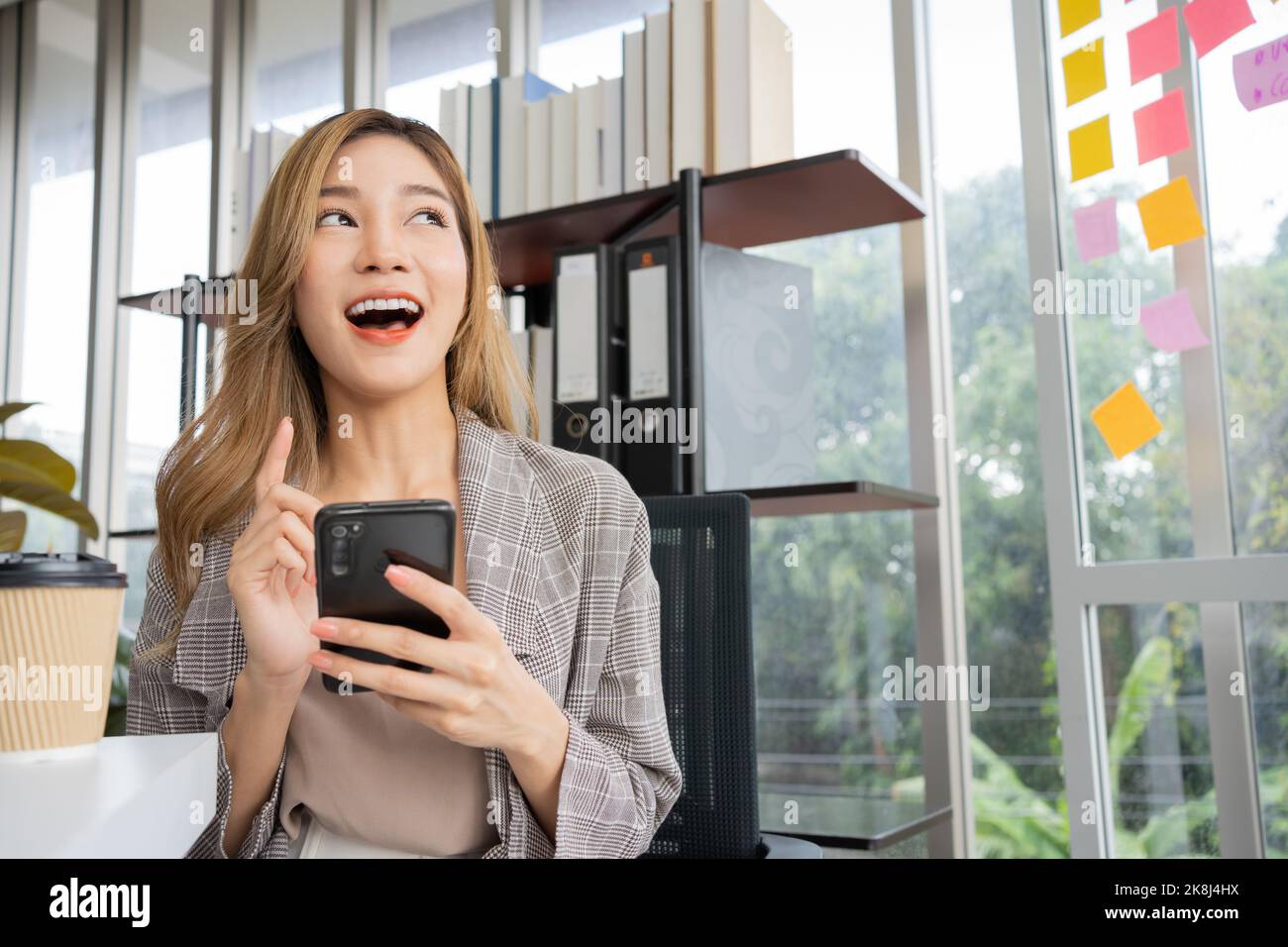 Happy young Asian women startup entrepreneur happy and excited smiling after getting message for success sign business contact, happy girl on workplac Stock Photo