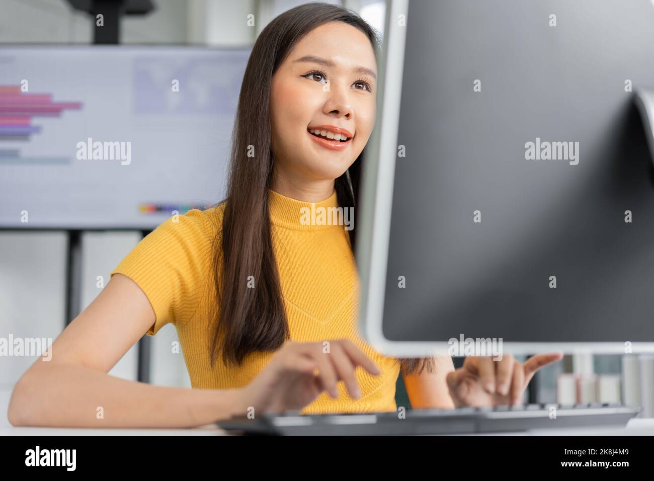 Portrait happy young programmer Asian woman work at start up technology office and using computer for coding application program and fully creative. C Stock Photo
