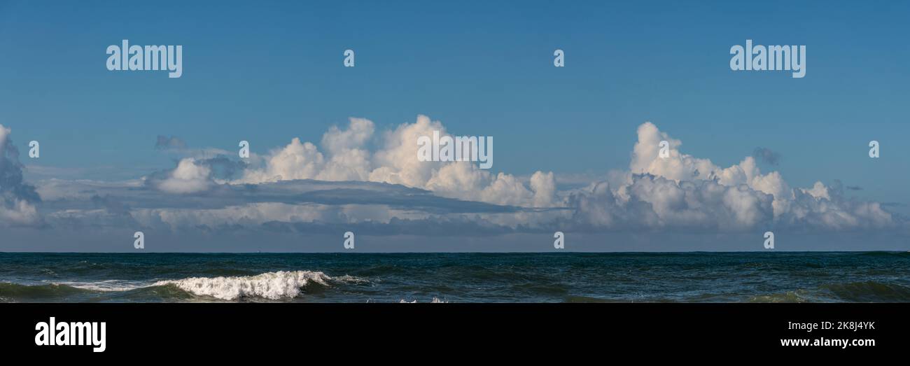 Panoramic skyline with magnificent clouds seen over the ocean. Stock Photo