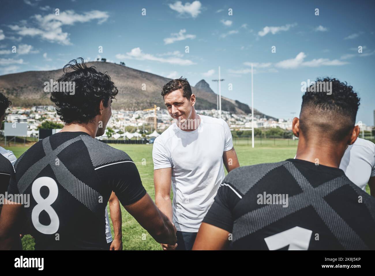 We will win next time. a group of young rugby players shaking each others hands to congratulate in playing a good game outside on a filed. Stock Photo