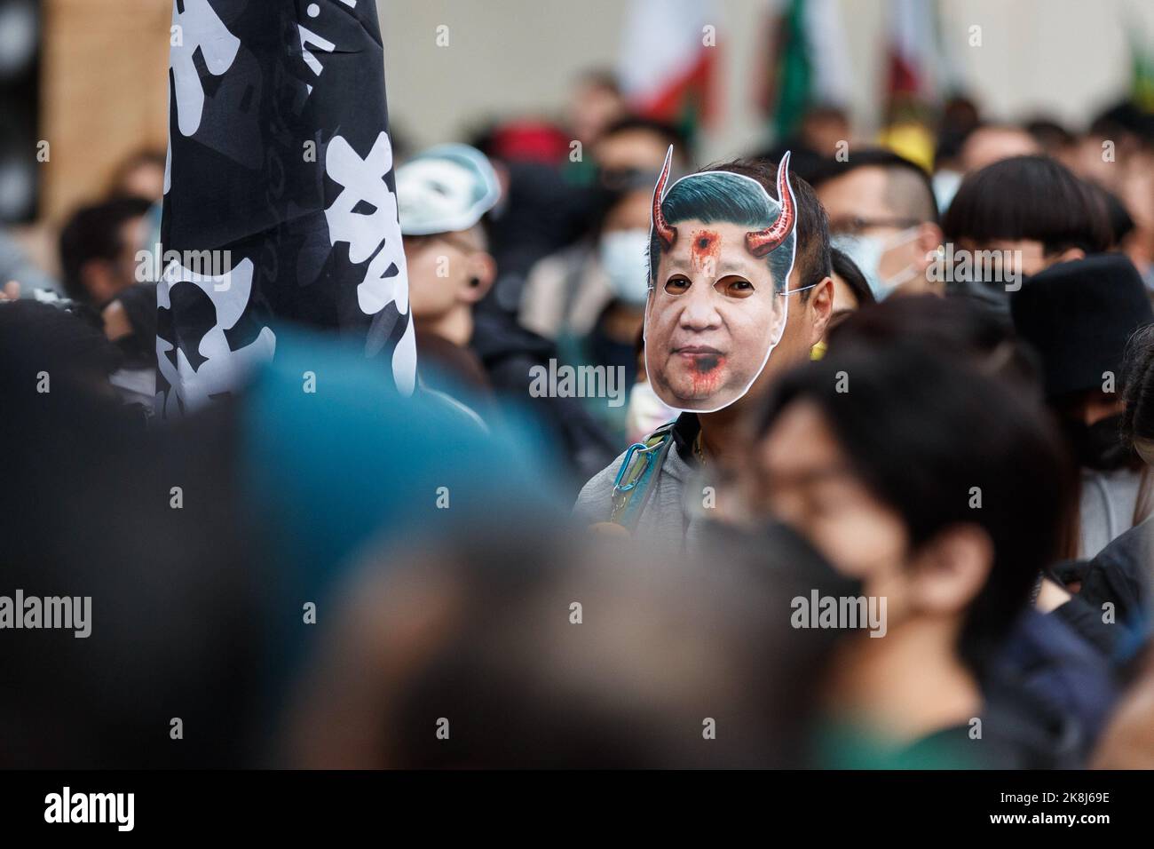 A protester wears Xi Jinping mask during an anti-Chinese Communist Party assembly opposite downing street in London. Hundreds of people marched under a rain storm from Downing Street via Chinatown to the Chinese Embassy in London, to protest against the assault incident in which a Hong Kong protester Bob Chan, who was seen being pulled into the grounds of a Chinese consulate in Manchester and beaten by staff on October 17, 2022. Hundreds of people marched under a rain storm from Downing Street via Chinatown to the Chinese Embassy in London to protest against the assault incident in which a Hon Stock Photo