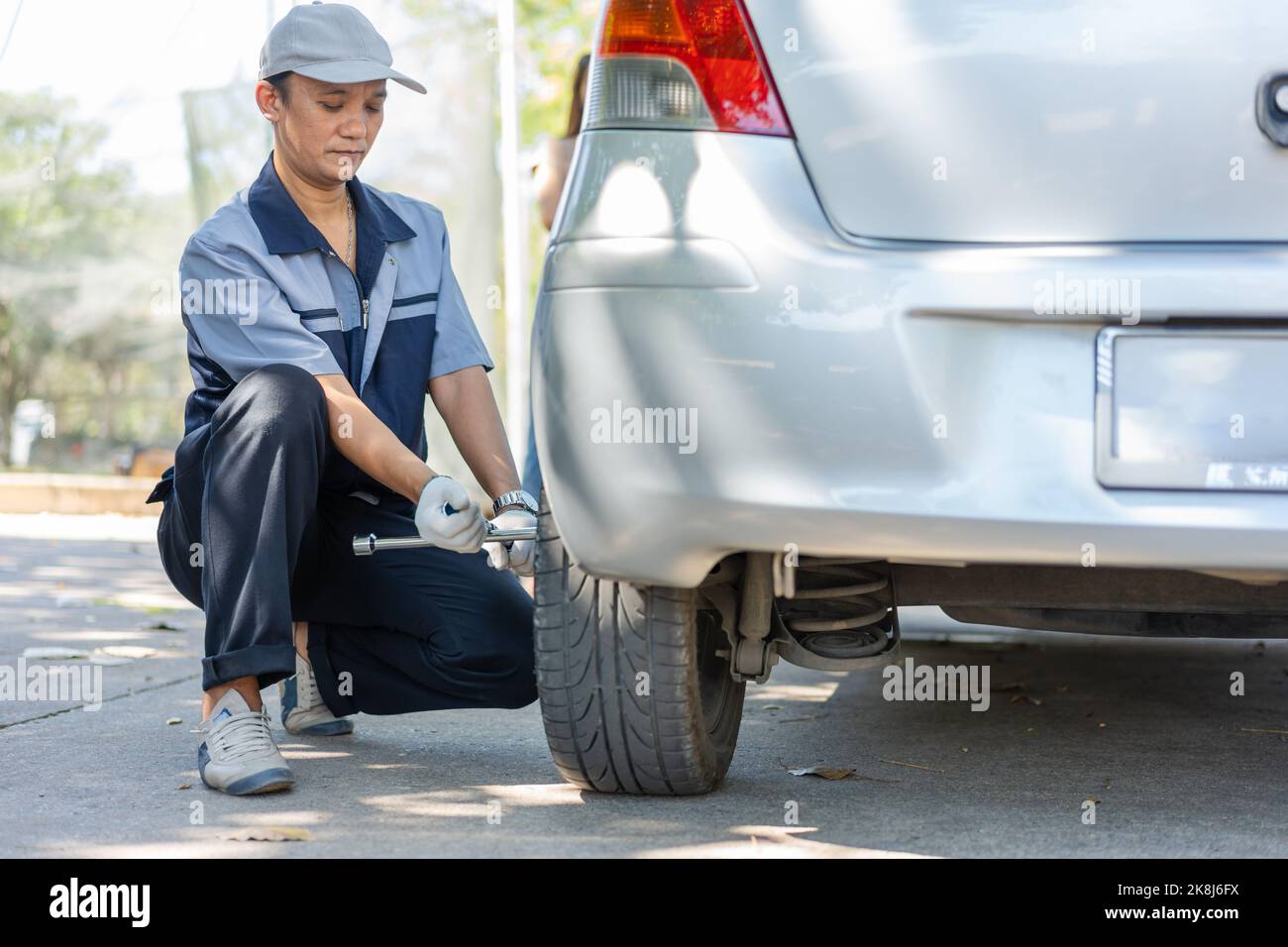 Expertise mechanic man in uniform using force trying to unscrew the