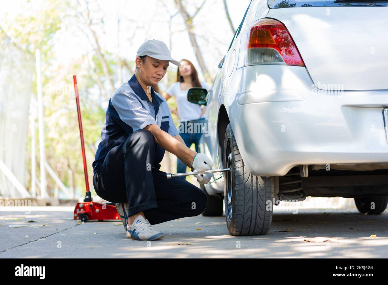 Expertise mechanic man in uniform using force trying to unscrew the