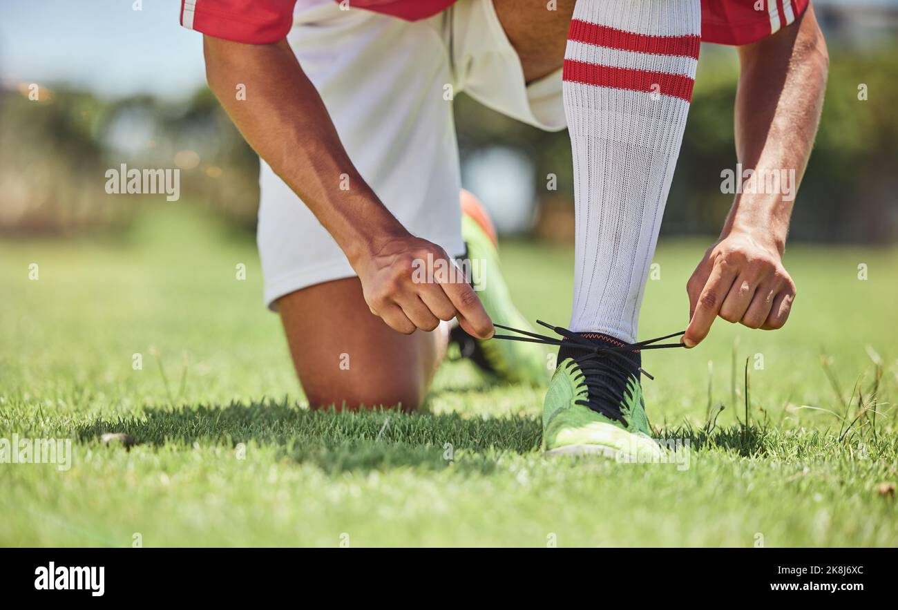 Hands, shoes and soccer player at a soccer field, tie lace and prepare for training, sports and fitness game. Football, hand and football player Stock Photo