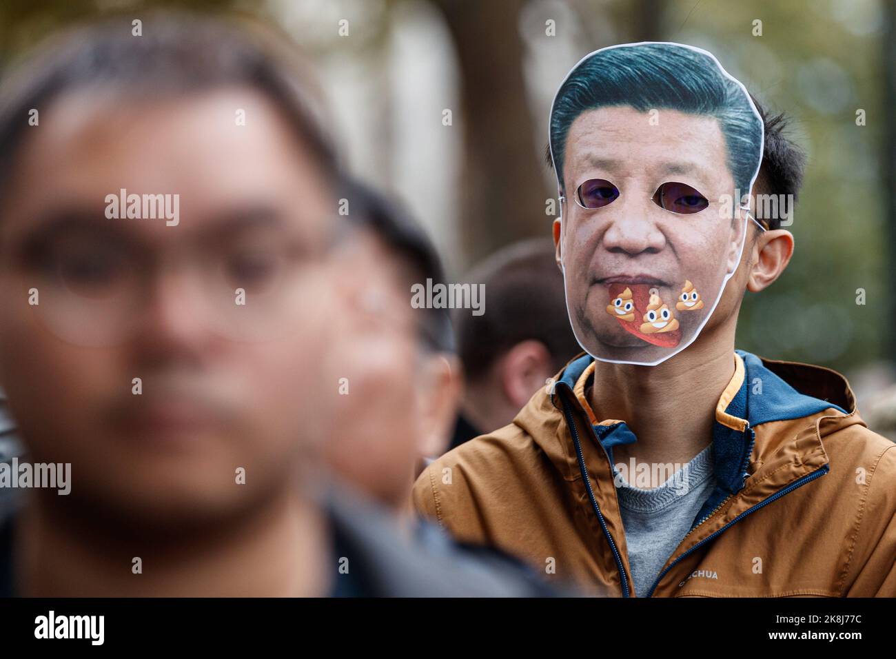 A protester wears Xi Jinping mask during an anti-Chinese Communist Party assembly opposite downing street in London. Hundreds of people marched under a rain storm from Downing Street via Chinatown to the Chinese Embassy in London, to protest against the assault incident in which a Hong Kong protester Bob Chan, who was seen being pulled into the grounds of a Chinese consulate in Manchester and beaten by staff on October 17, 2022. Hundreds of people marched under a rain storm from Downing Street via Chinatown to the Chinese Embassy in London to protest against the assault incident in which a Hon Stock Photo