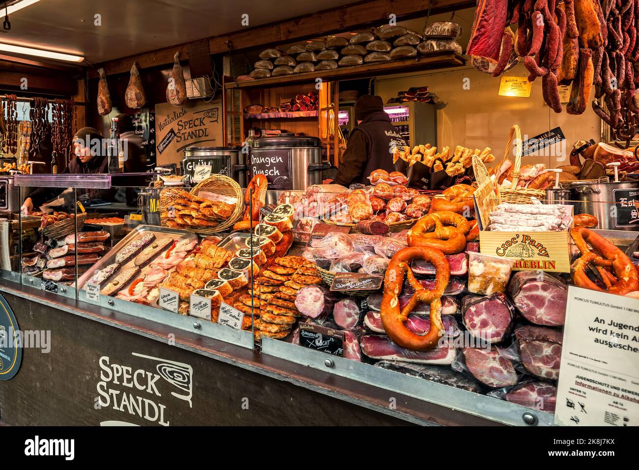 Kiosk with different types of smoked and cured meat along with traditional bakery products during famous Christmas market in Vienna, Austria. Stock Photo