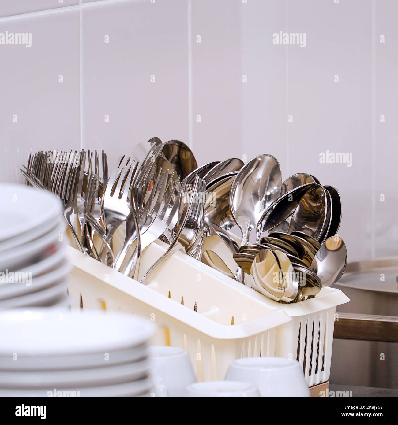Clean spoons and forks in a stand on the table Stock Photo Alamy
