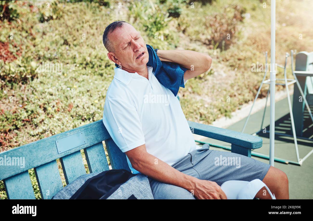 Im exhausted. a handsome mature sportsman taking a moment to breathe during tennis practise. Stock Photo