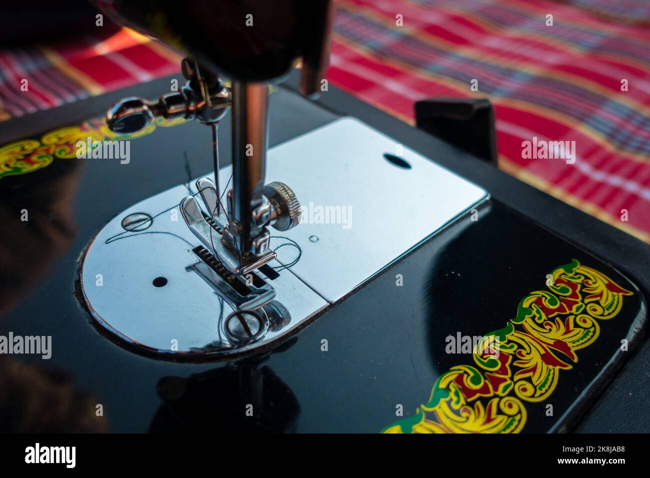 february 12th 2022, Dehradun City India. Hands operating manual Sewing machine needle bar with thread. Stock Photo