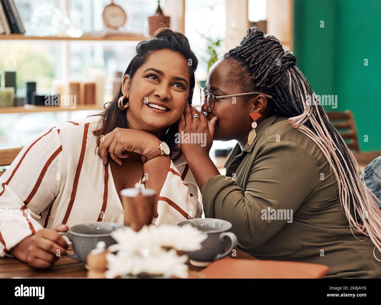 Have I got some news for you. two young women gossiping at a cafe. Stock Photo