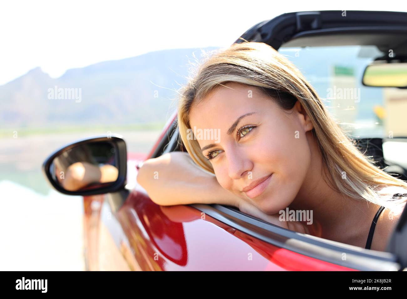 Portrait of a happy convertible car driver looking away Stock Photo