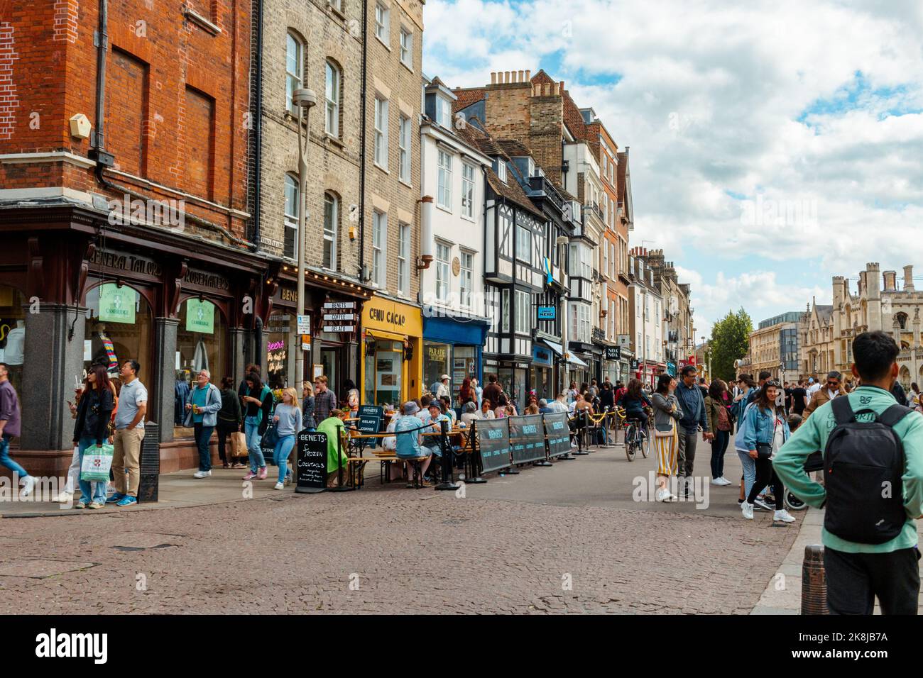A view of Kings Parade, Cambridge, UK showing lots of tourists eating and drinking outdoors Benets cafe. Stock Photo