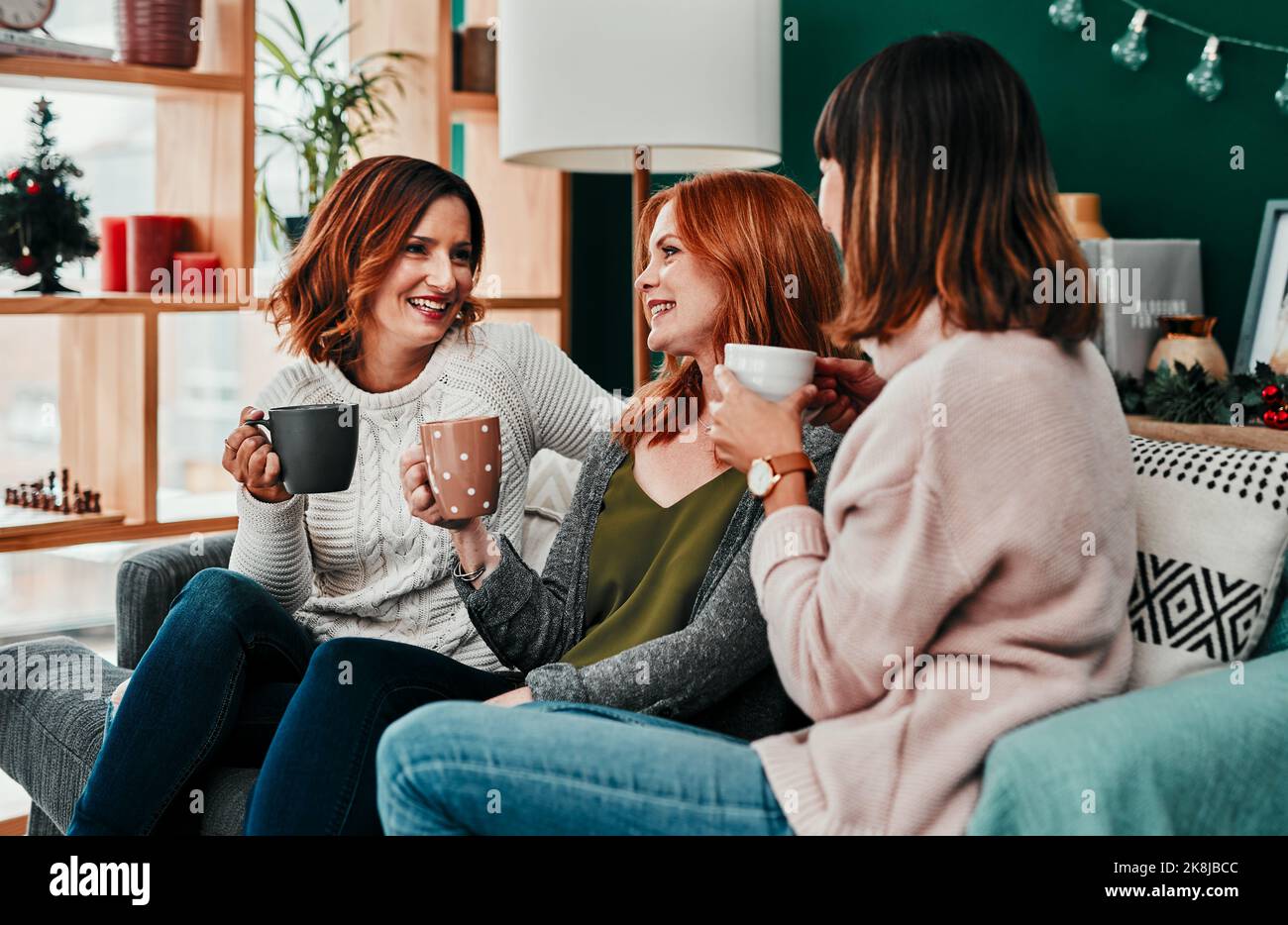 I always have time for the two of you. three attractive middle aged women having coffee together during Christmas eve at home. Stock Photo