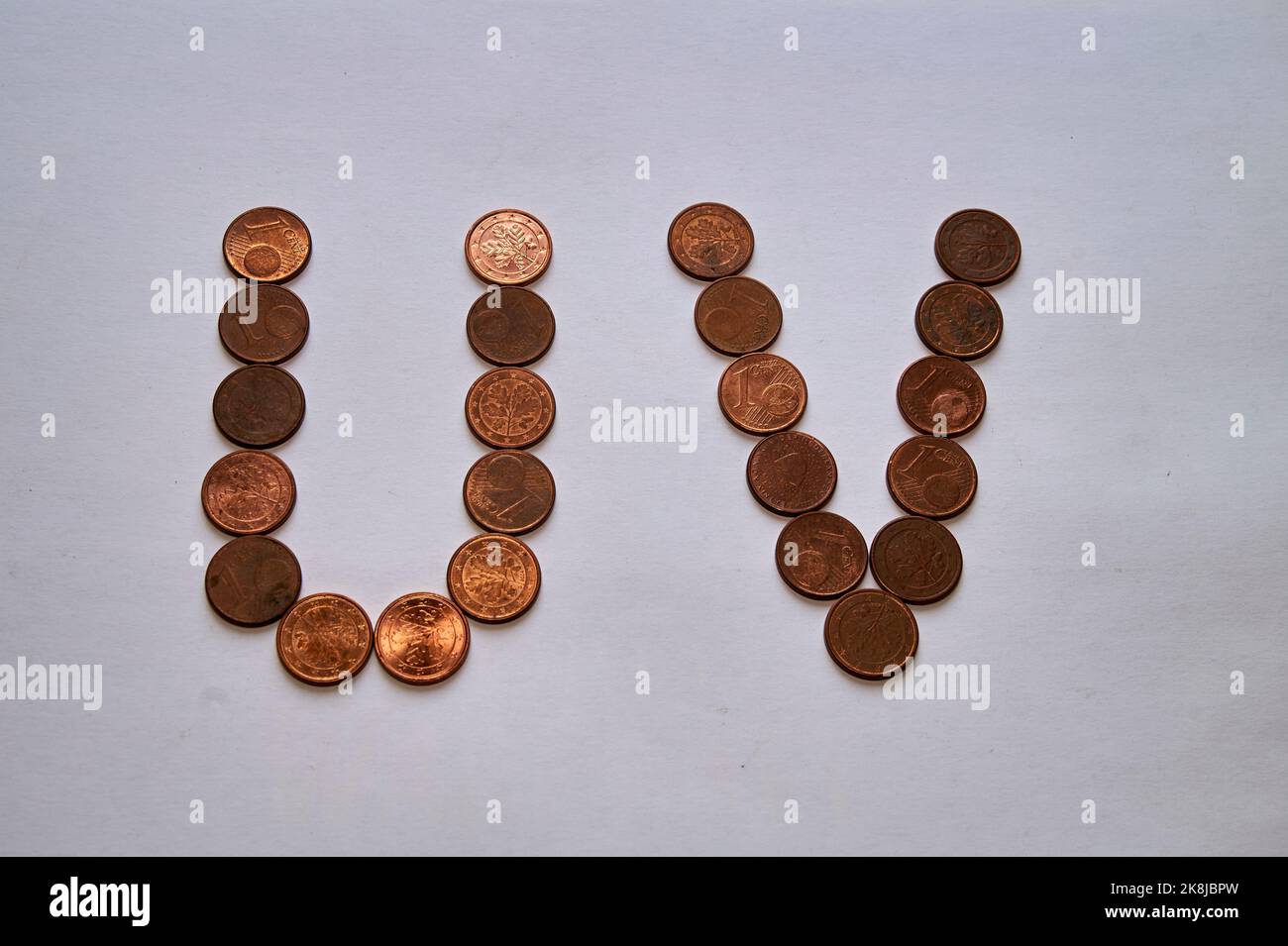 Letters u v of copper coins insulated on a white sheet of paper Stock ...