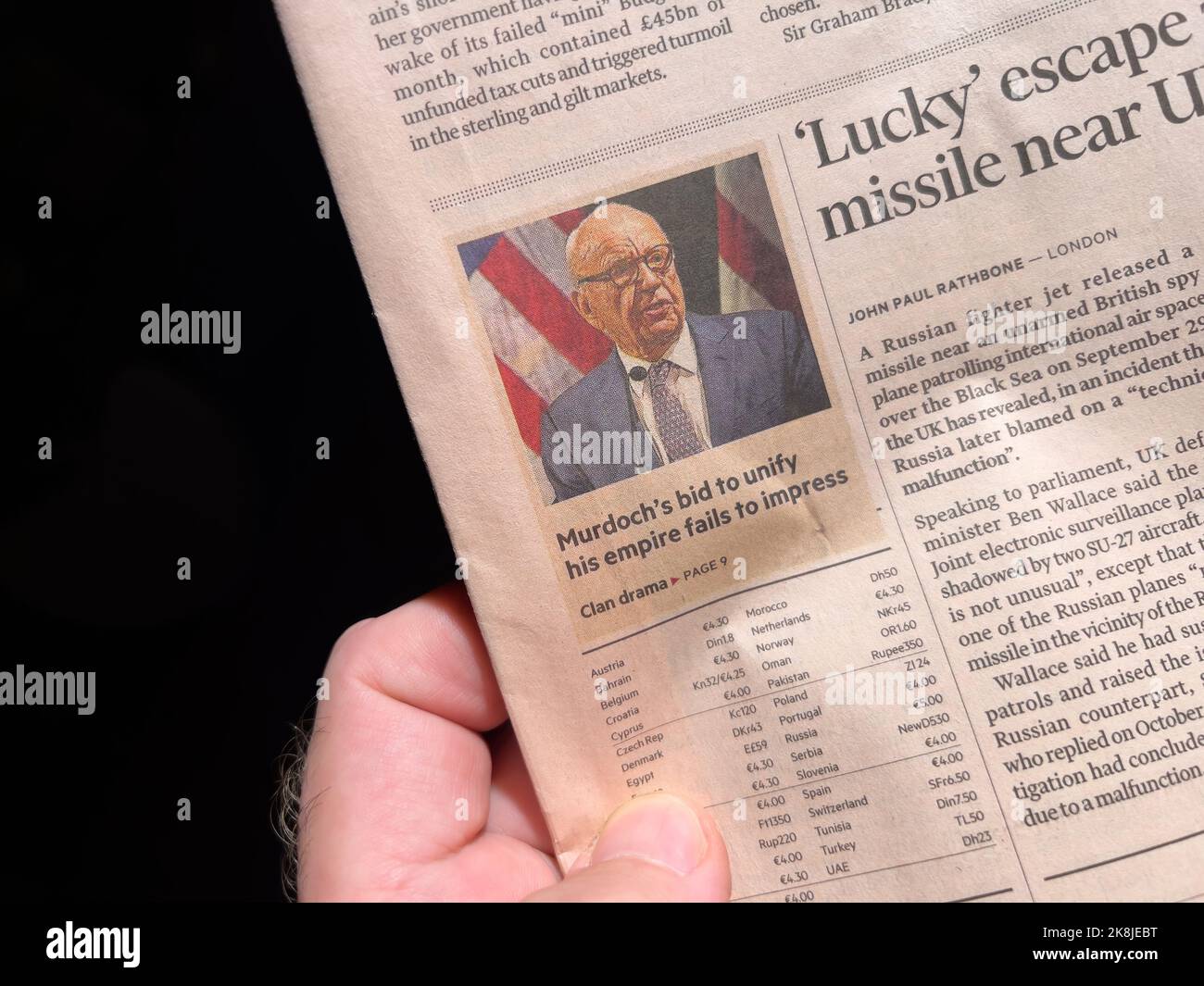 LONDON, ENGLAND - OCTOBER 20: POV male hand reading Financial Times with headline Murdoch's bid to unify his empire fails to impress Stock Photo