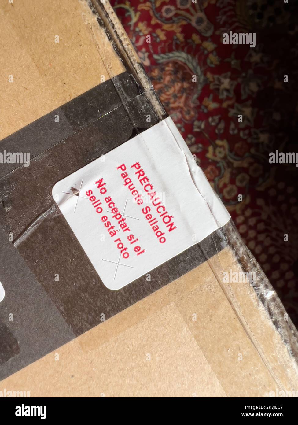 View from above - Message on the cardboard in spanish language translated as - caution sealed package do not accept if seal is broken Stock Photo