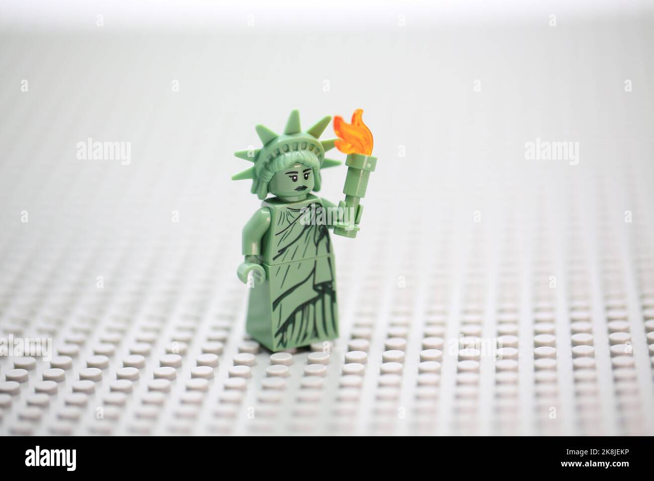 woman dressing like Statue of Liberty and stand with the grey background Stock Photo