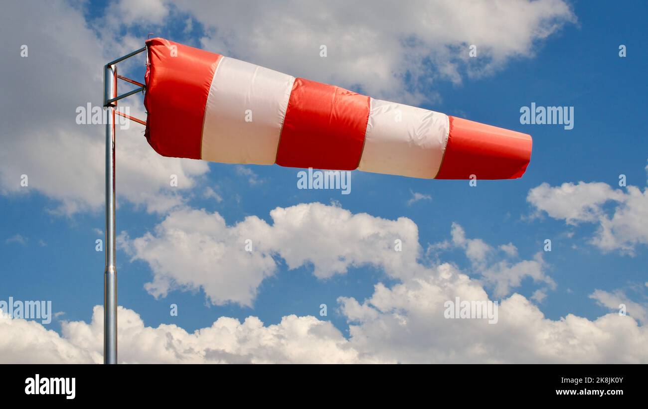 Windsock. Windsock flag. Wind direction indicator. Wind intensity. Windsock in front of blue sky. Stock Photo