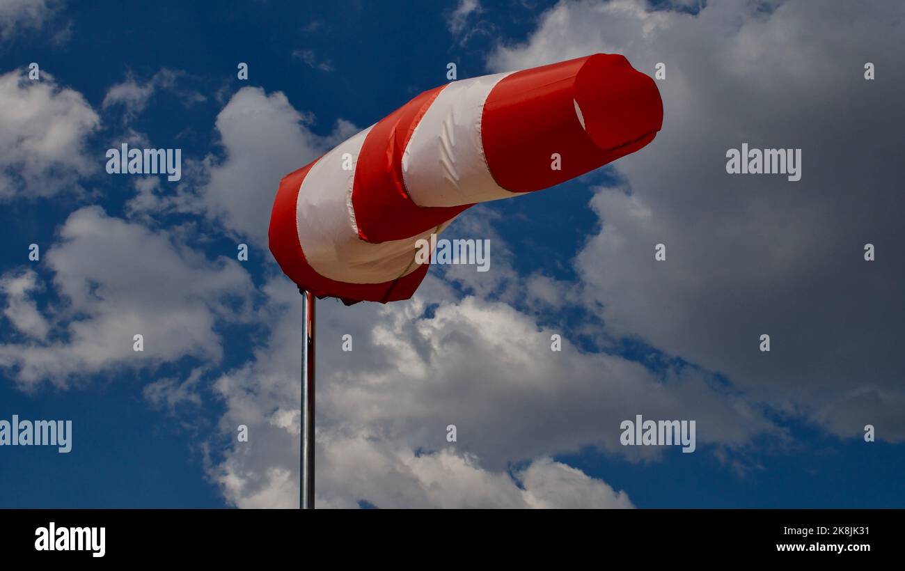 Windsock. Windsock flag. Wind direction indicator. Wind intensity. Windsock in front of blue sky. Stock Photo