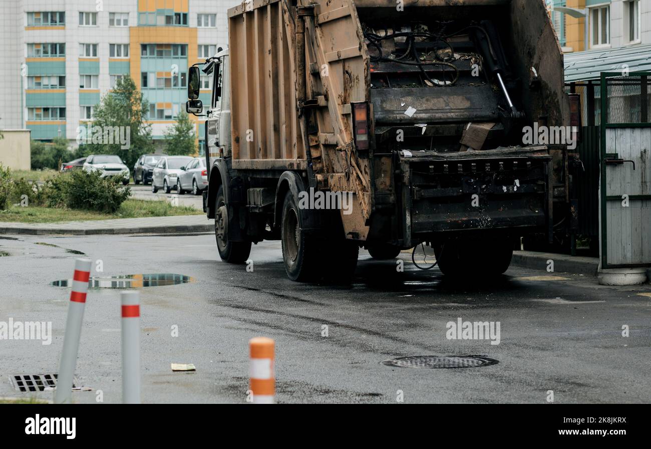 Garbage disposal lorry at city street. Waste dump truck on town road. Municipal and urban services. disposal and recycling. Stock Photo