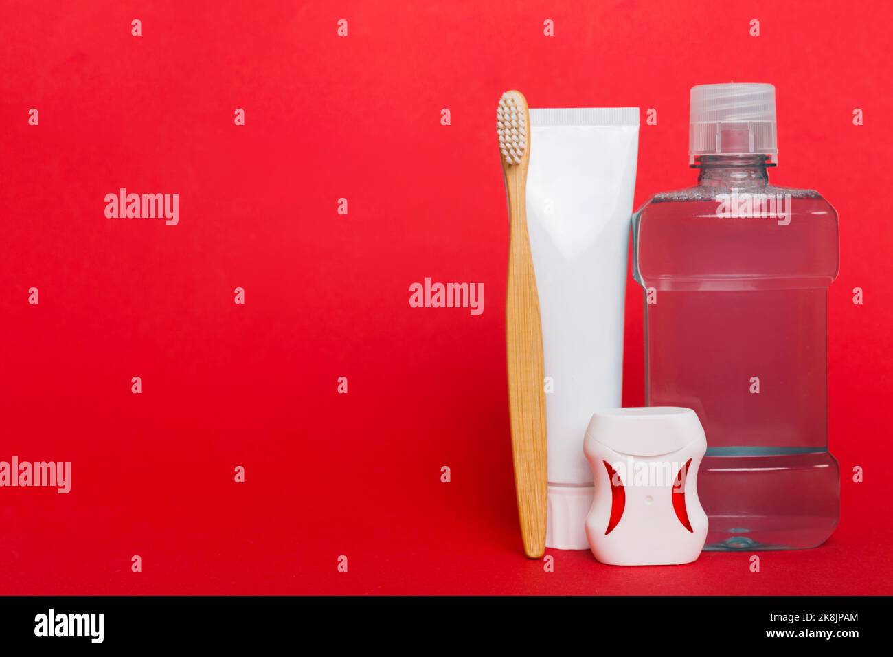 Mouthwash and other oral hygiene products on colored table top view with copy space. Flat lay