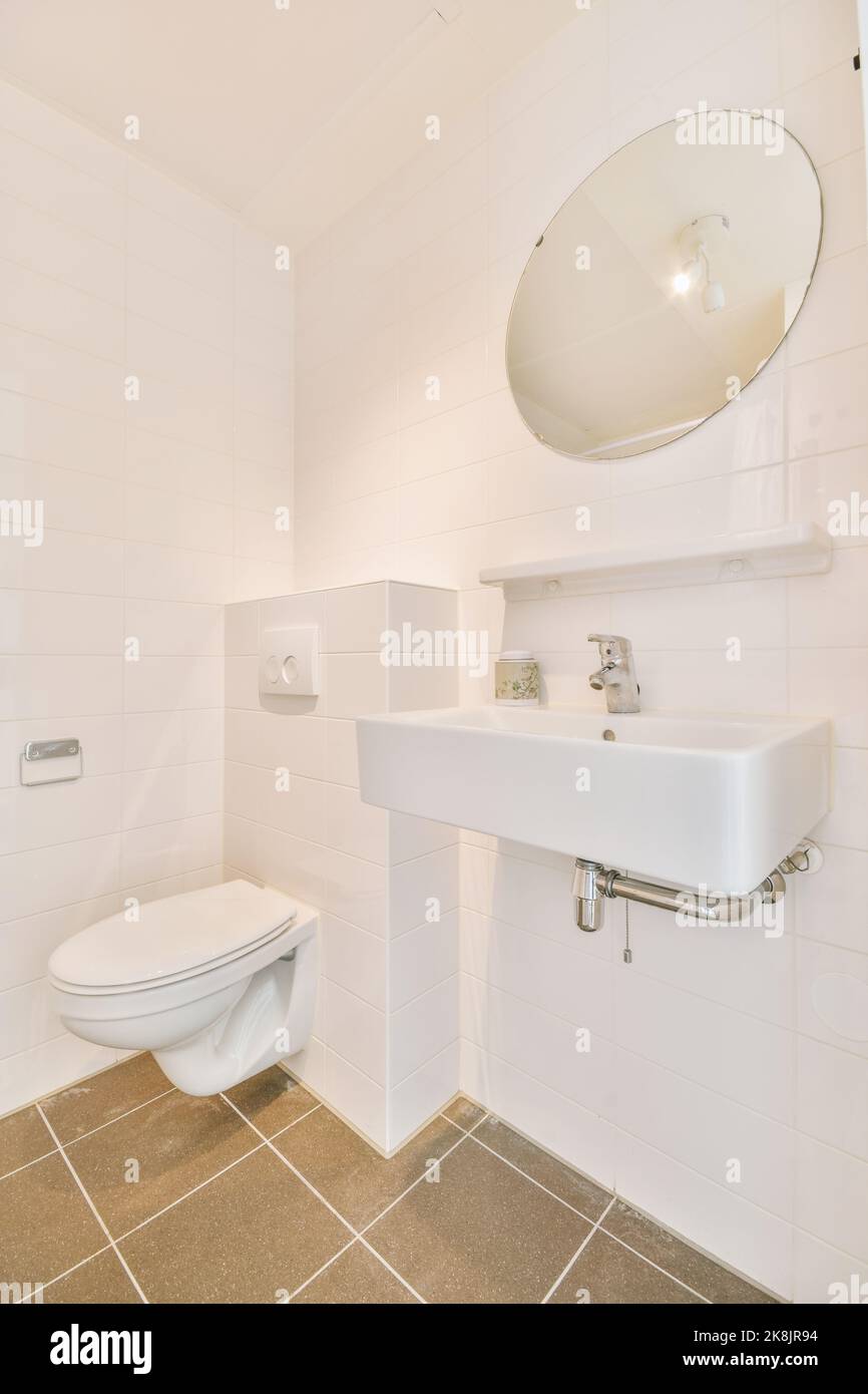 Bathroom with white tiled walls and open shower near sink and toilet in