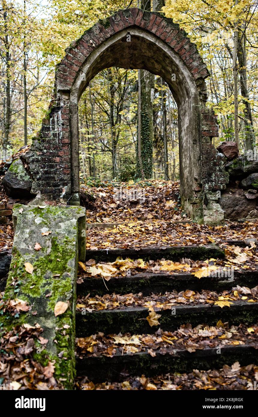 old medieval cemetery gate. Arch shaped building, no fence, entrance in abandoned burial ground made of bricks with staircase Stock Photo